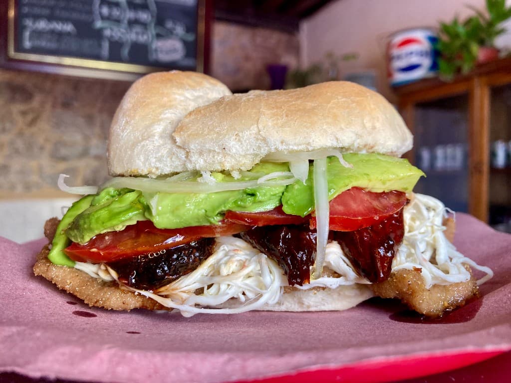 Torta milanesa con quesillo, aguacate y chipotle